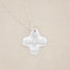 sterling silver shining light cross necklace on beige background