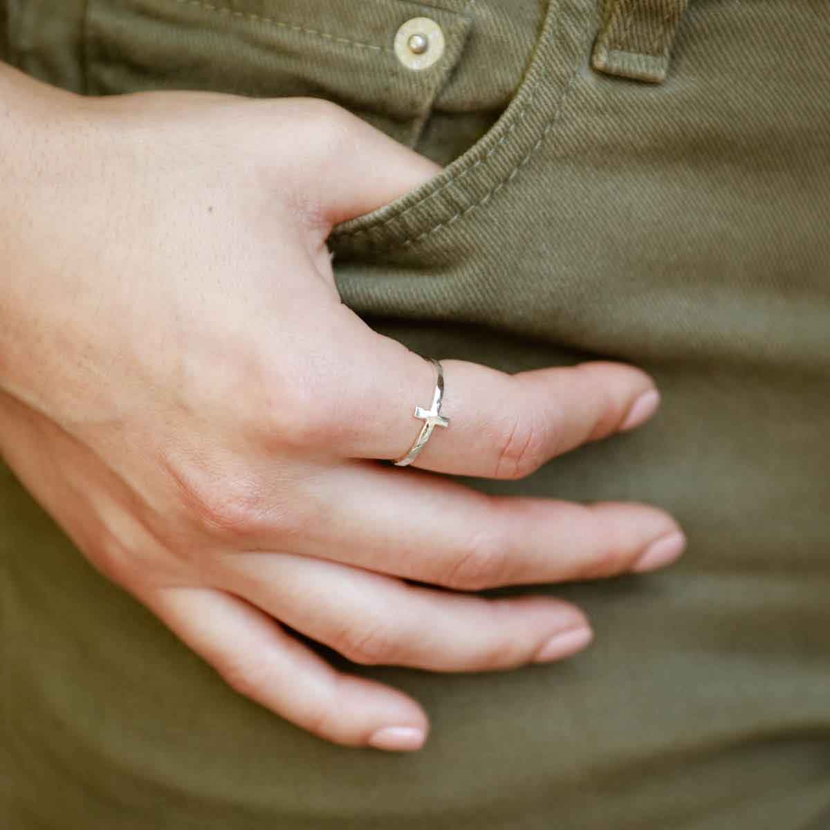 woman holding a sterling silver Simple Hammered Cross Ring