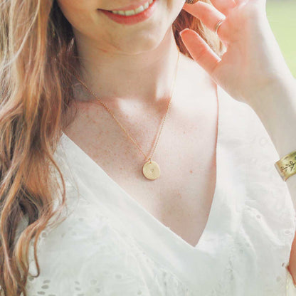 girl wearing small and mighty heart disc necklace gold plated