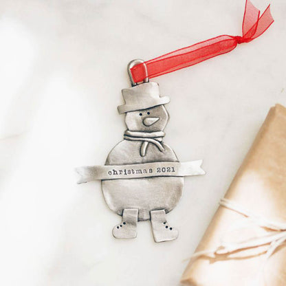 Snowman ornament hand-molded and cast in pewter hung from a sheer red ribbon and personalized with a phrase