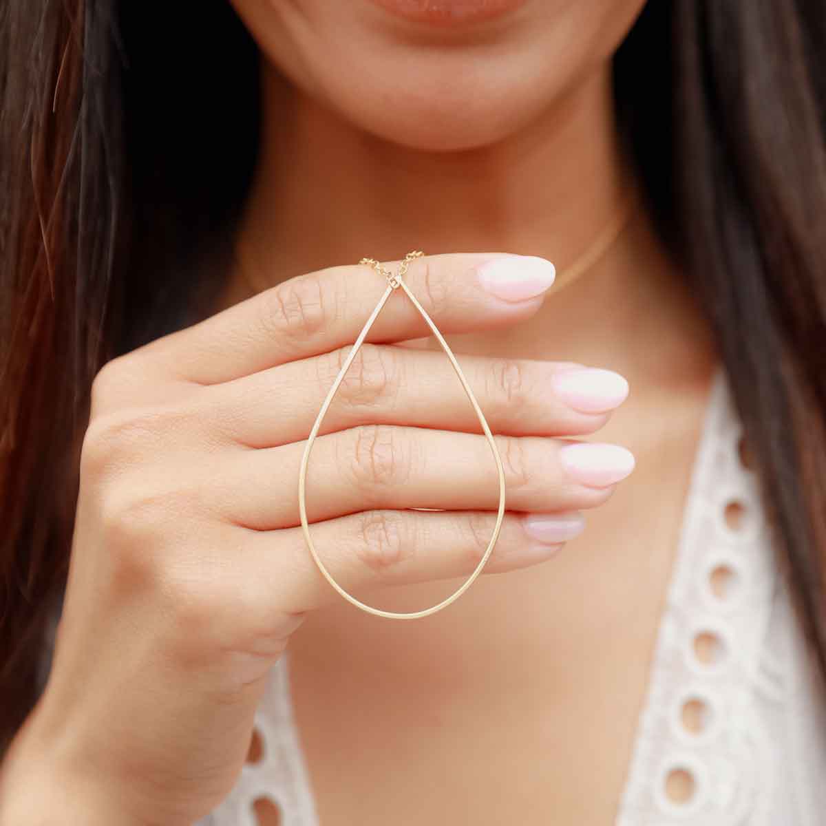 Girl holding a gold filled Sorrow and Joy Teardrop Necklace