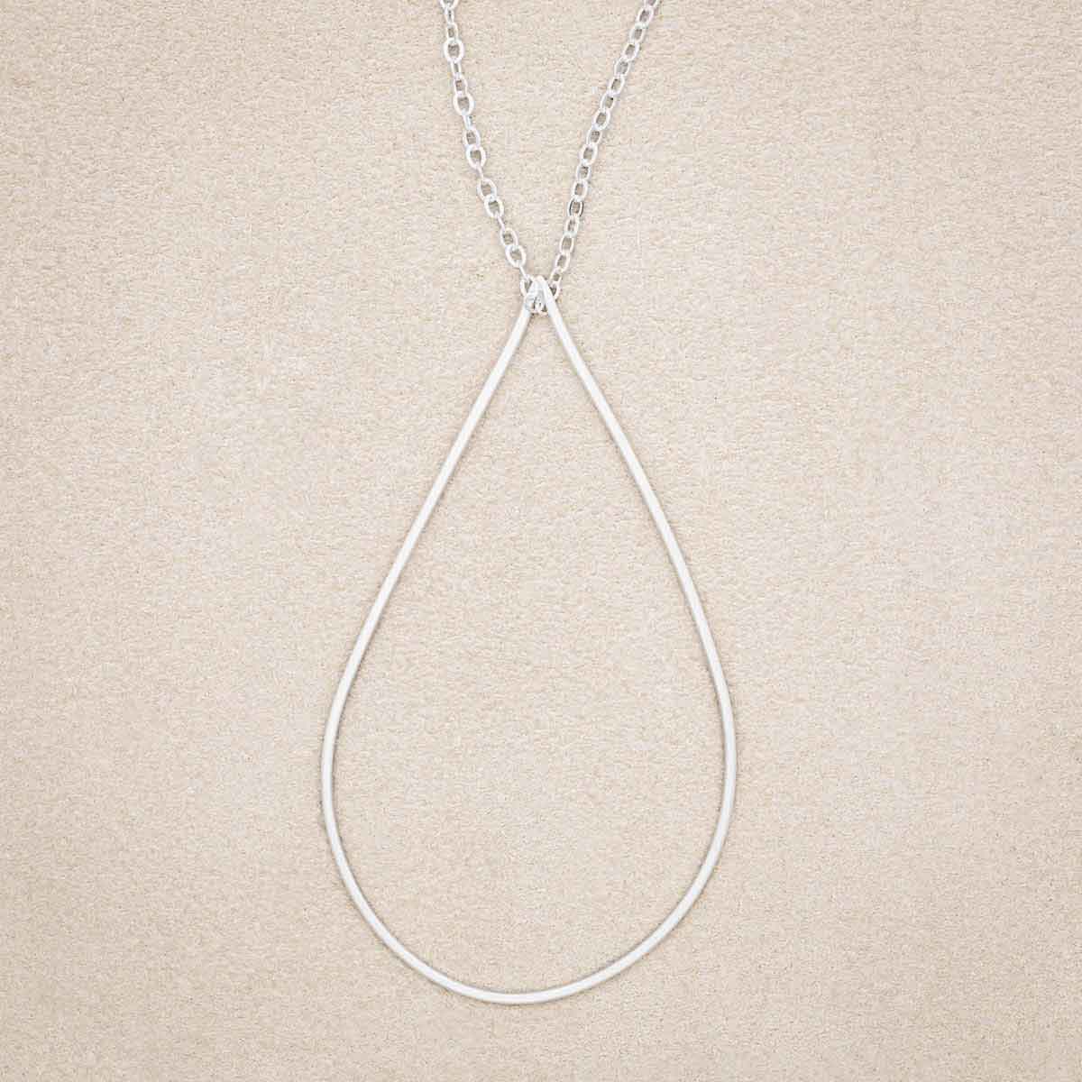 Sorrow and Joy Teardrop Necklace, handcrafted in sterling silver, on suede background
