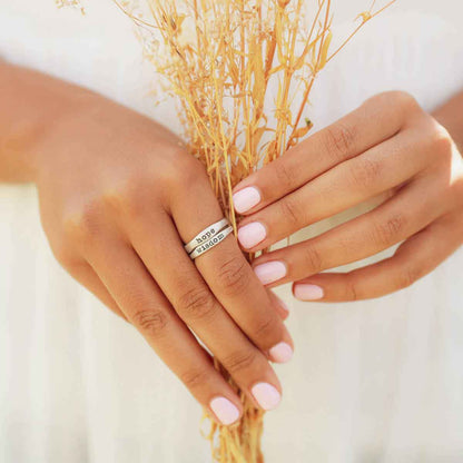 Woman wearing her Personalized sterling silver stackable name rings with her husband