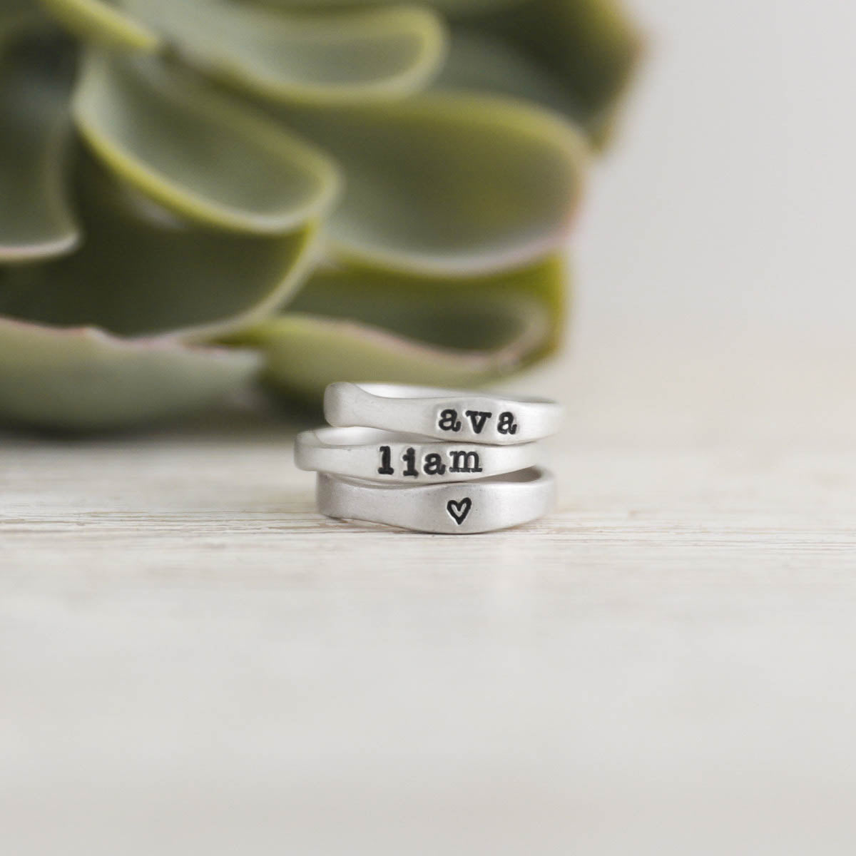 Woman wearing her Personalized sterling silver stackable name rings with other handcrafted sterling silver jewelry 