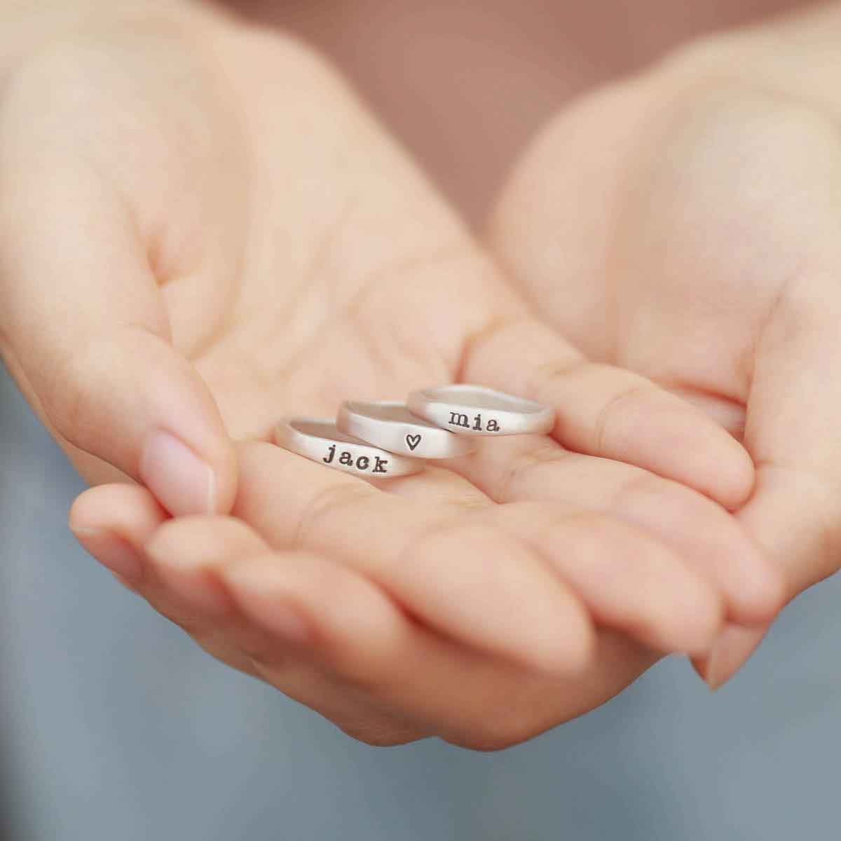 girl wearing personalized sterling silver stackable name ring trio 