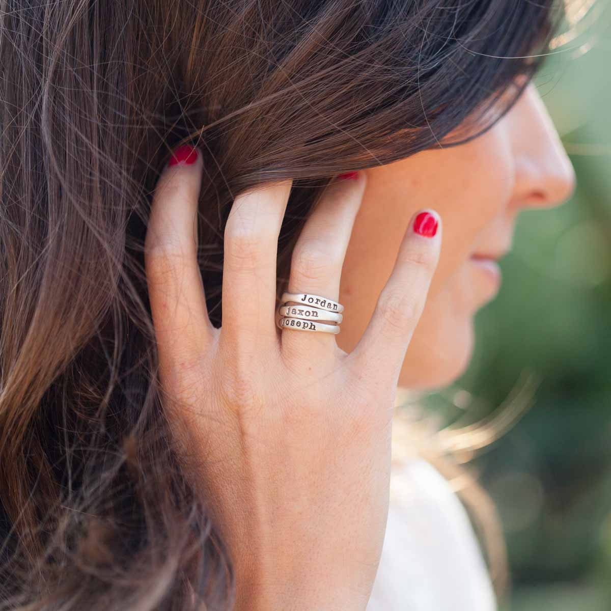 girl wearing personalized sterling silver stackable name ring trio 