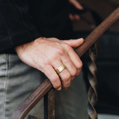 Man wearing Strong + True ring handcrafted in 14k yellow gold with a hammered finish and personalized with a meaningful name