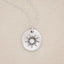 sterling silver sunburst diamond necklace on beige background