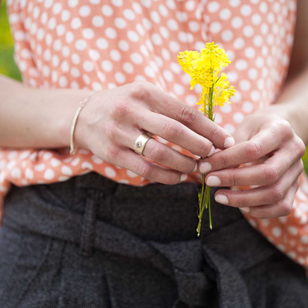 girl wearing her 10k yellow gold sunburst diamond ring with a 3mm conflict free diamond along with other gold jewelry