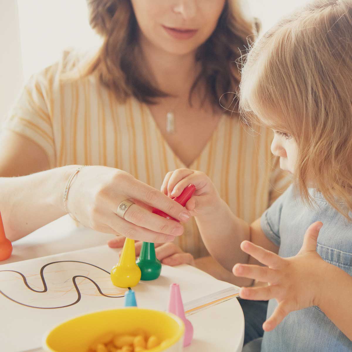 woman wearing her sterling silver sunburst diamond ring with a 3mm conflict free diamond and with her child