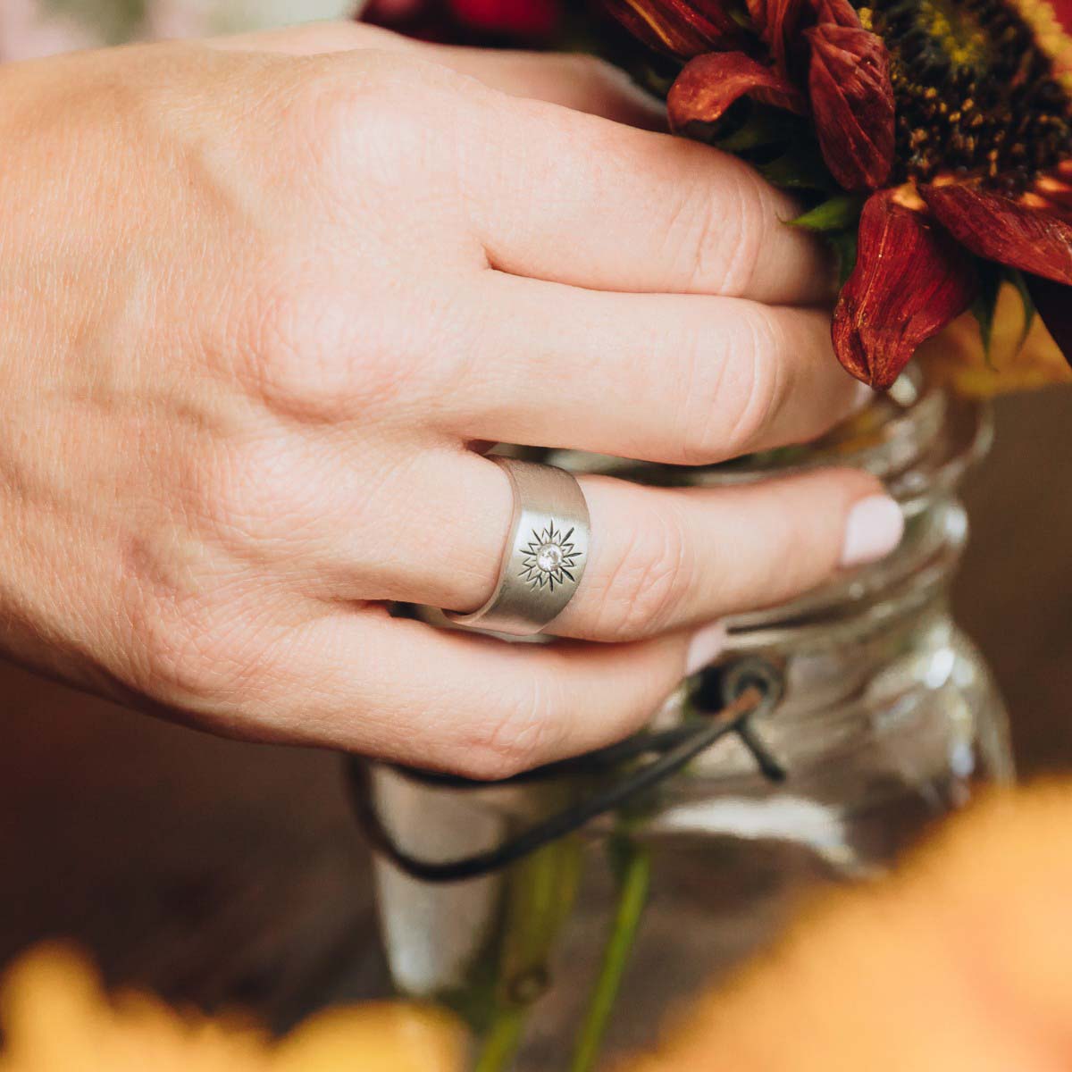 woman wearing her sterling silver sunburst diamond ring with a 3mm conflict free diamond 