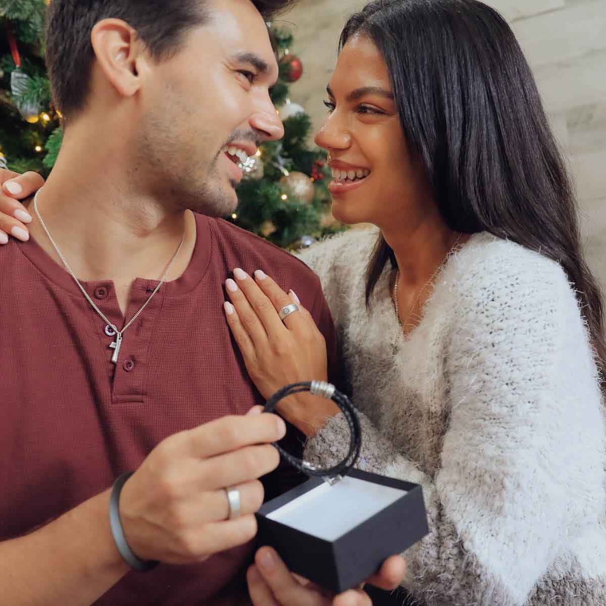  hugging a guy in front of christmas tree