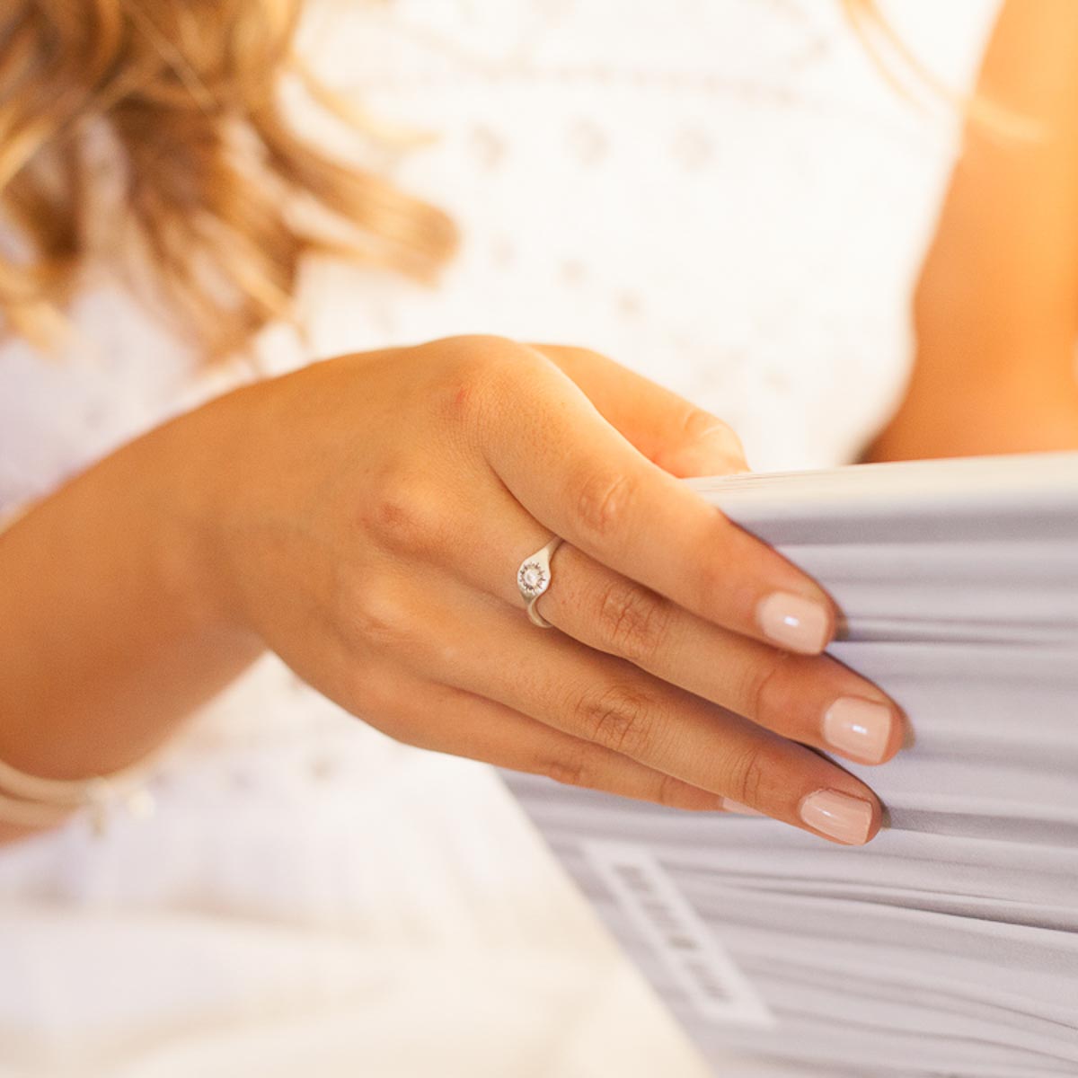 Girl wearing Sunburst stacking ring handcrafted in sterling silver and set with a 3mm bright genuine diamond