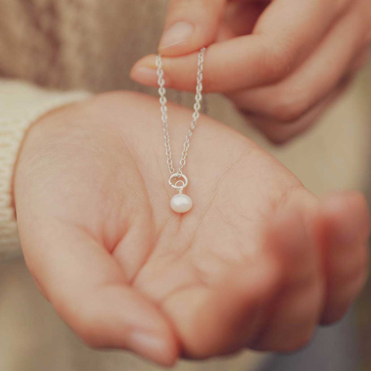 Hand holding a Sweet Dainty Freshwater Pearl Necklace