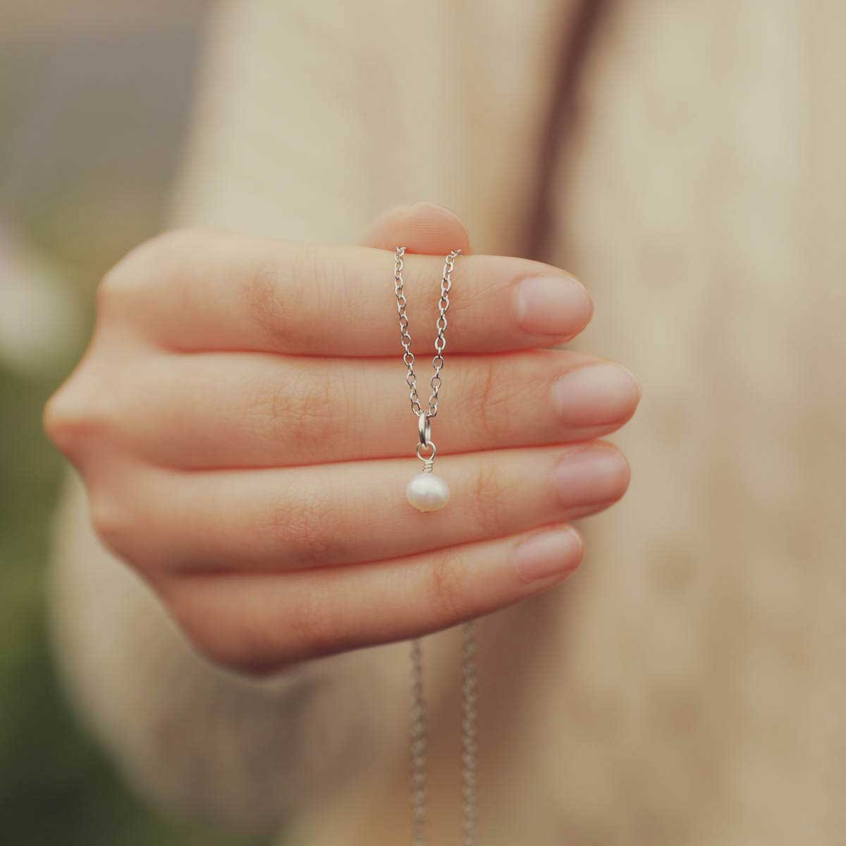 Hand holding a Sweet Dainty Freshwater Pearl Necklace