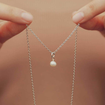 Hand holding a Sweet Dainty Freshwater Pearl Necklace