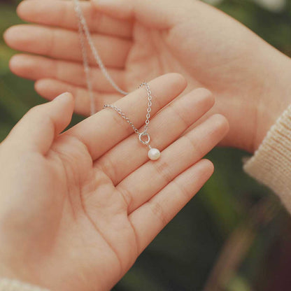 Hand holding a Sweet Dainty Freshwater Pearl Necklace