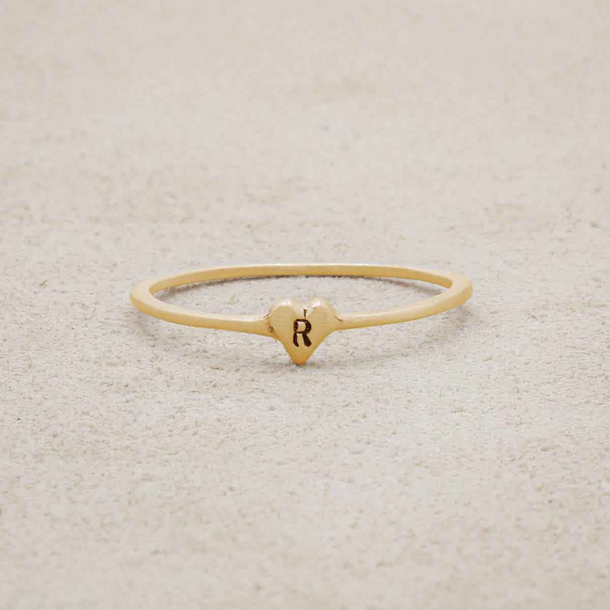 10k yellow gold Sweet Love Initial Ring - One Heart on beige background