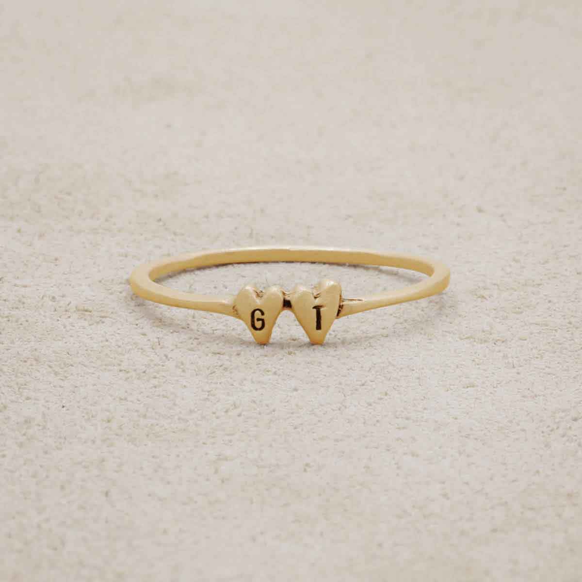 10k yellow gold Sweet Love Initial Ring - Two Hearts, personalized with two initials, on a beige background