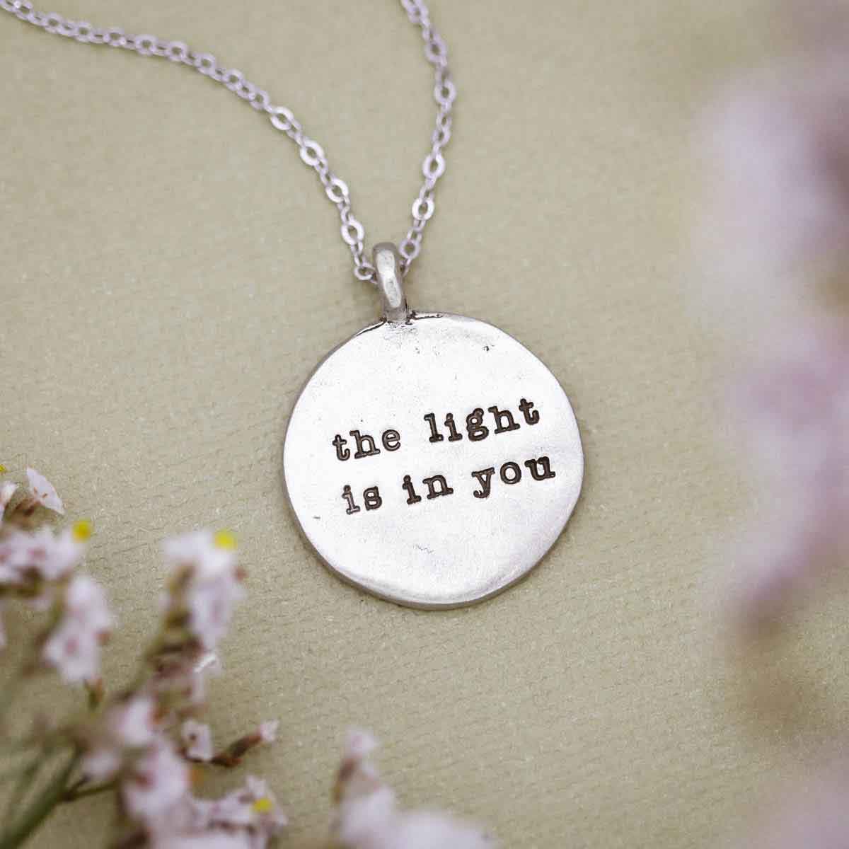 hand holding a The Light is in You Necklace