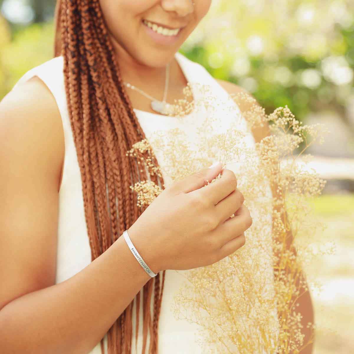 Girl wearing several sterling silver accessories including a thin sterling cuff