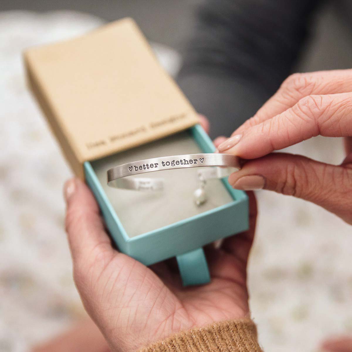 Thin sterling cuff bracelet being displayed from original packaging