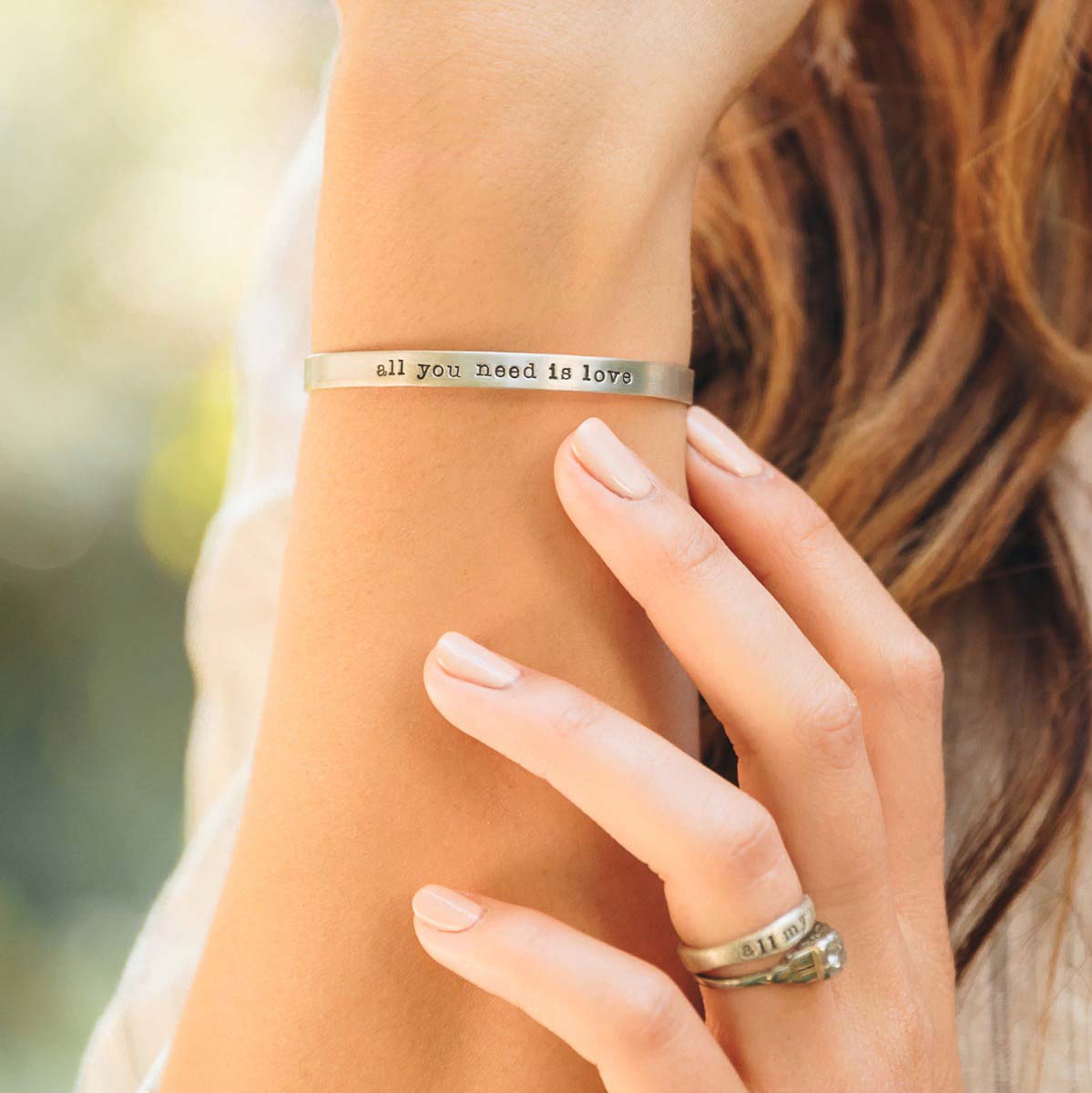 Girl showing her personalized sterling silver jewelry including her thin sterling cuff