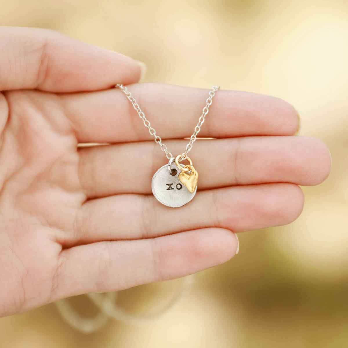 girl wearing this is love necklace handcrafted in pewter with small gold plated heart charm