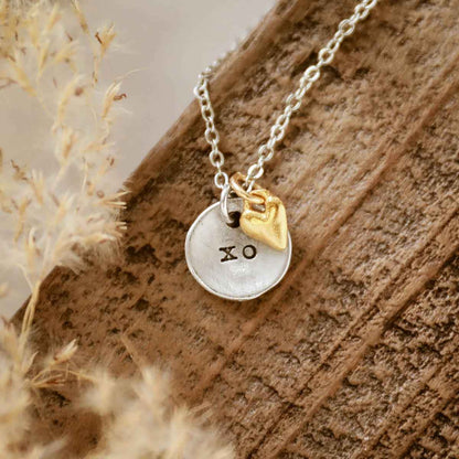 girl wearing this is love necklace handcrafted in pewter with small gold plated heart charm