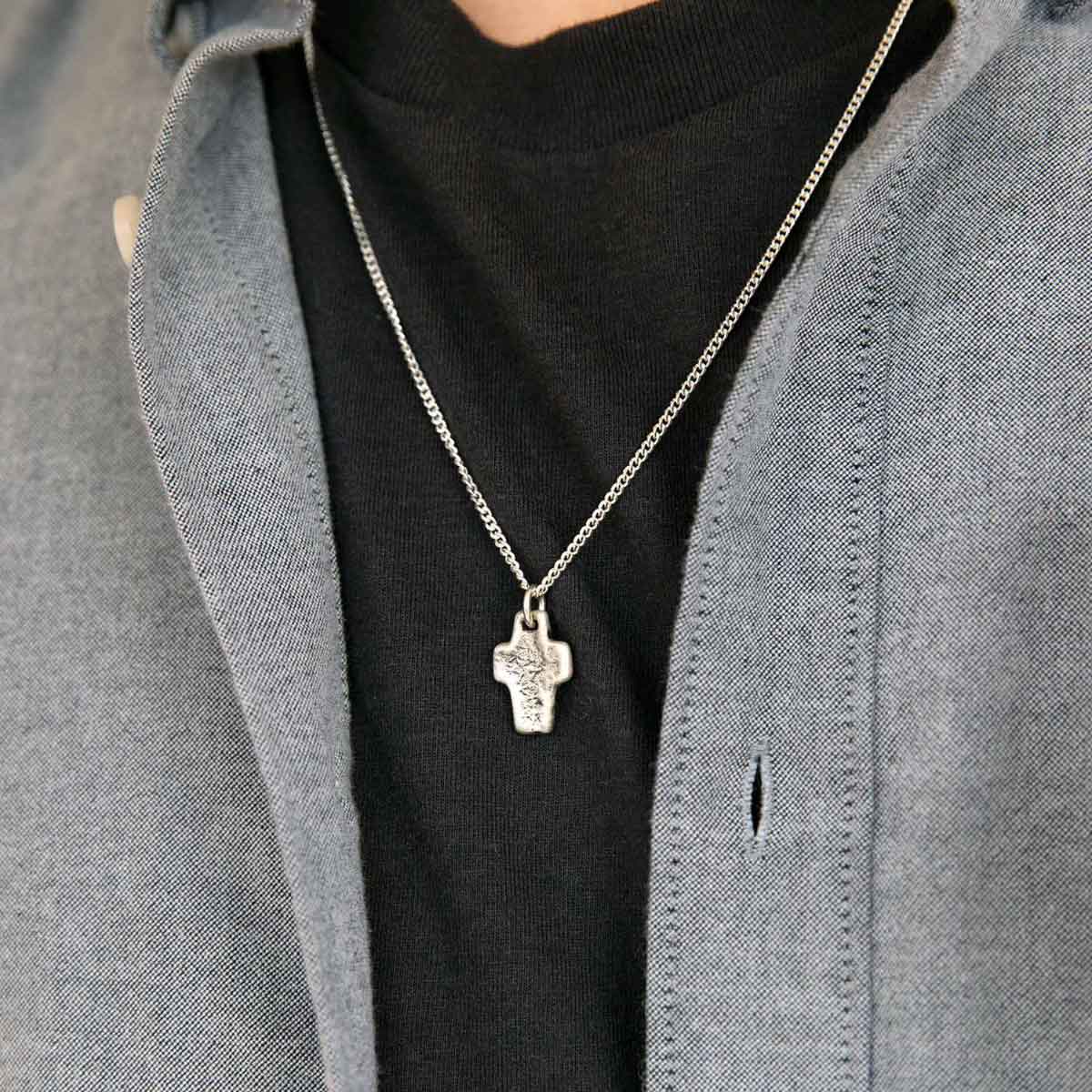 man wearing a Thrive Cross necklace handcrafted in sterling silver with choice of chain