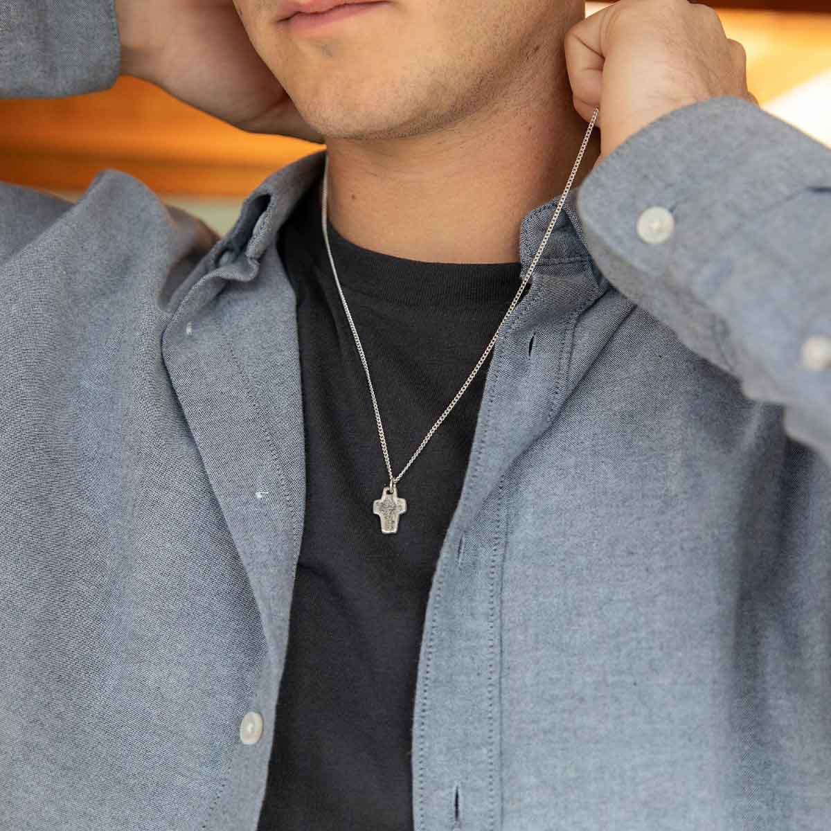 man wearing a Thrive Cross necklace handcrafted in sterling silver with choice of chain