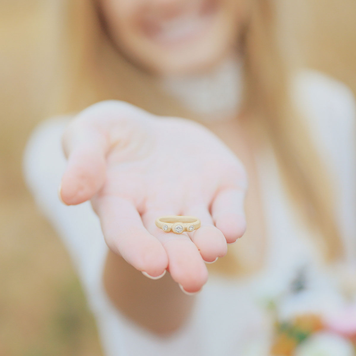 girl holding a togetherness ring handcrafted in 14k yellow gold