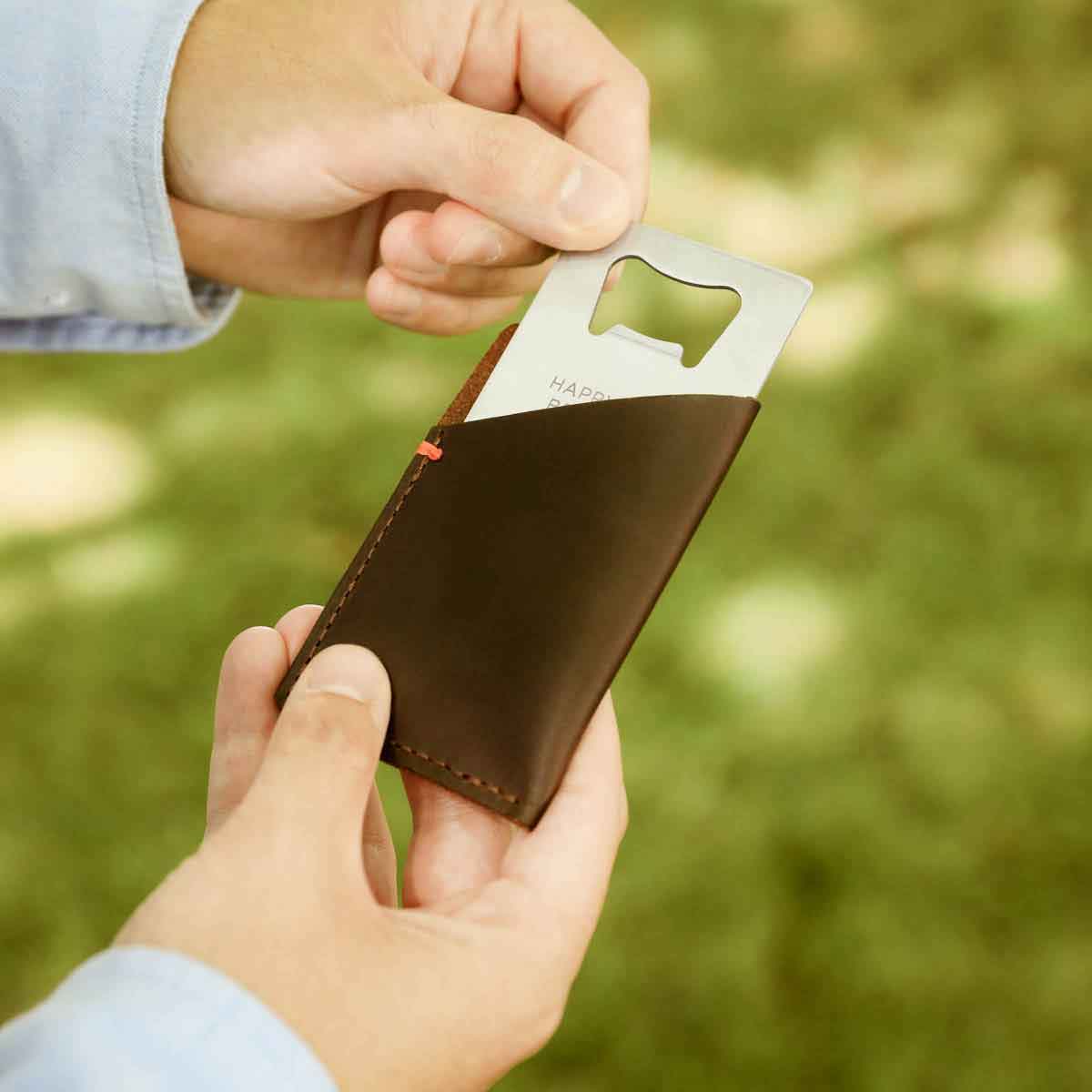 hand putting the personalized Trailblazer Bottle Opener into the Leather Wallet 