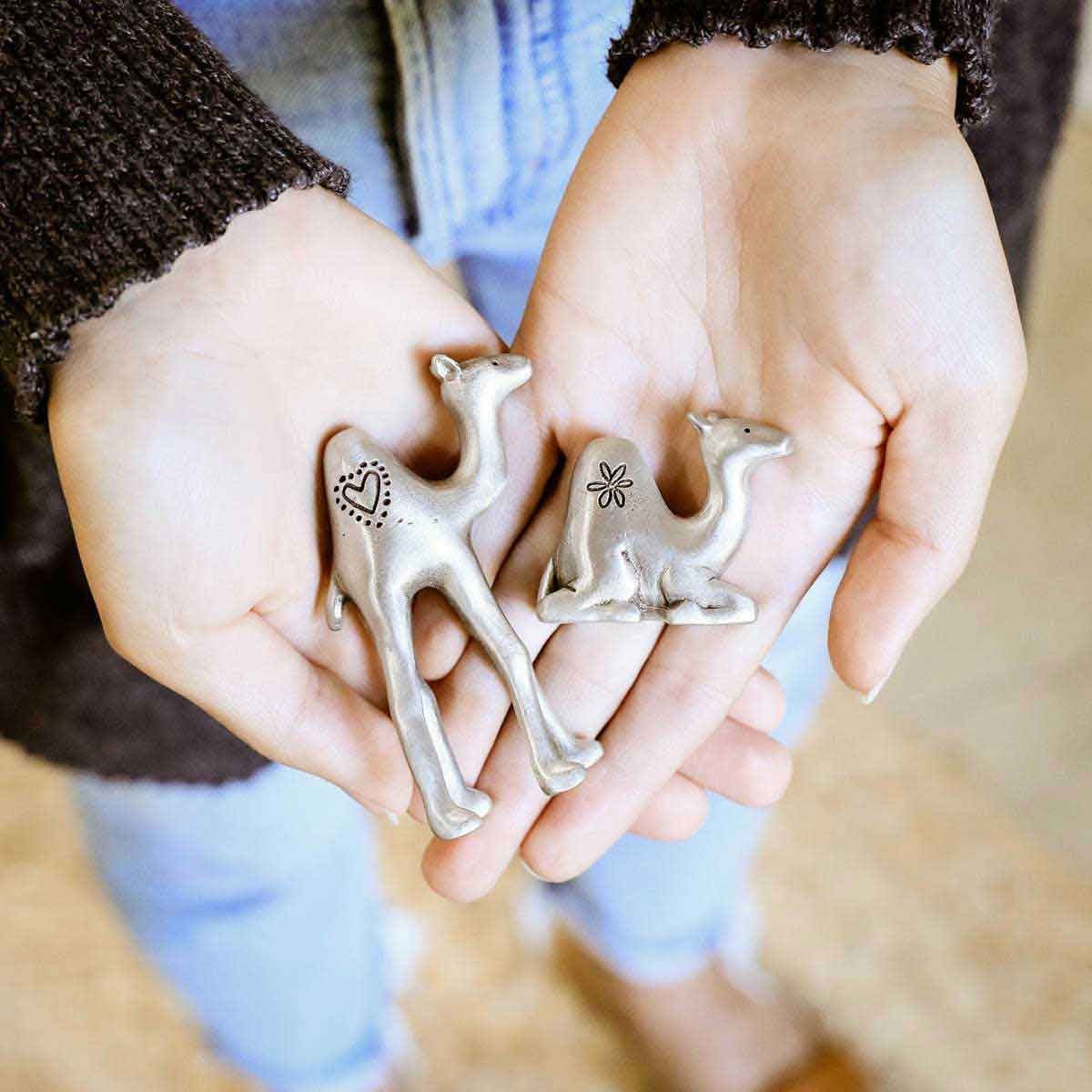 Two hands holding the Two Wise Camels Nativity Figurine Set