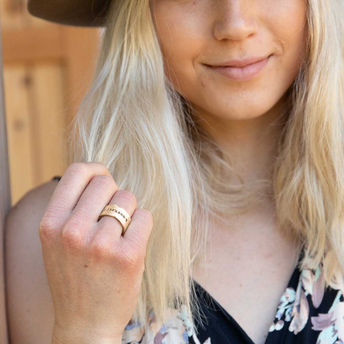 Girl wearing Very fine line ring handcrafted in 14k yellow gold with a satin/antiqued finish customizable with a name