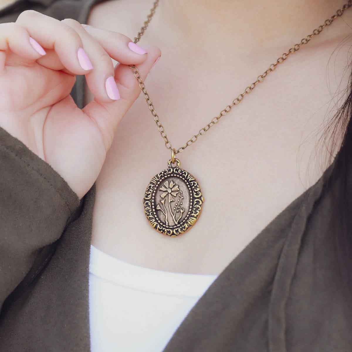 girl wearing a gold plated vintage cameo necklace engraved with flowers 