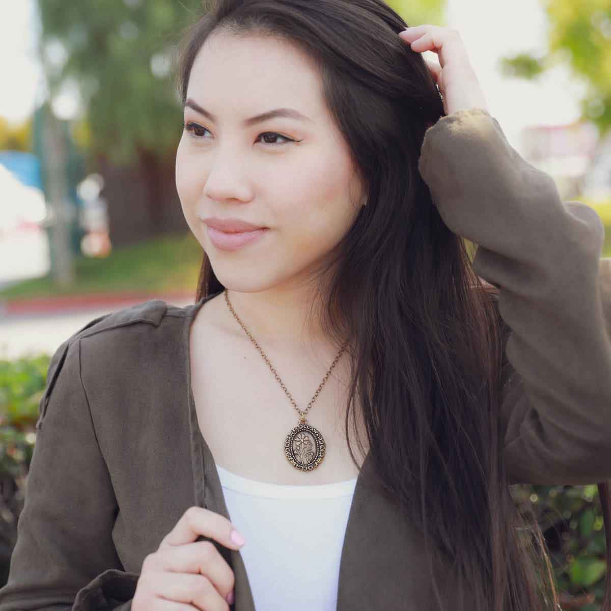 girl wearing a gold plated vintage cameo necklace engraved with flowers 