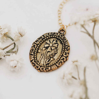 gold plated vintage cameo necklace with floral background