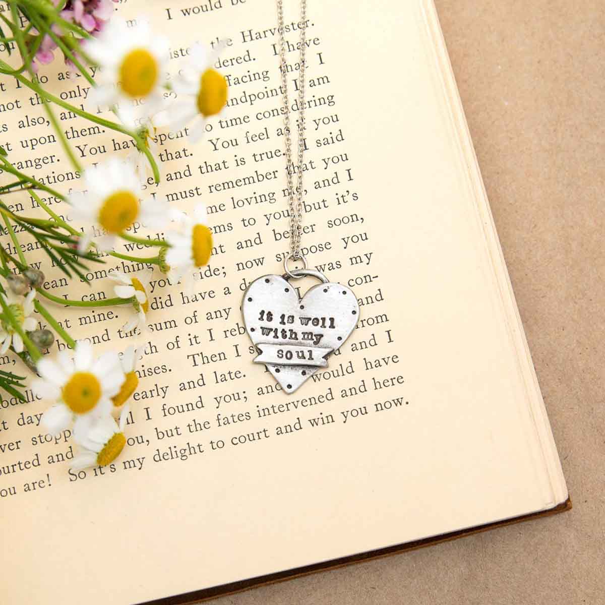 well with my soul pewter necklace on a book