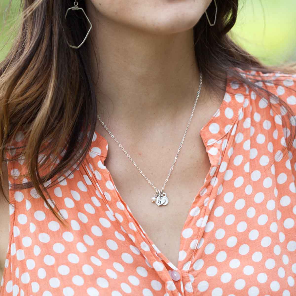 girl wearing sterling silver wild about you initials necklace with personalized initial charms and tiny freshwater pearl