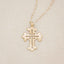 14k yellow gold work of art cross necklace, on beige background