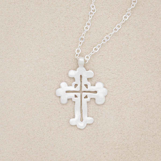 sterling silver work of art cross necklace on beige background