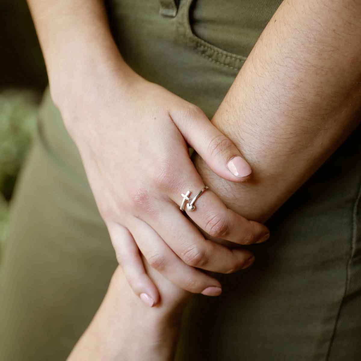 woman holding a sterling silver Wrapped in Christ’s Love Adjustable Cross Ring