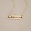 14k yellow gold written with love necklace, on beige background