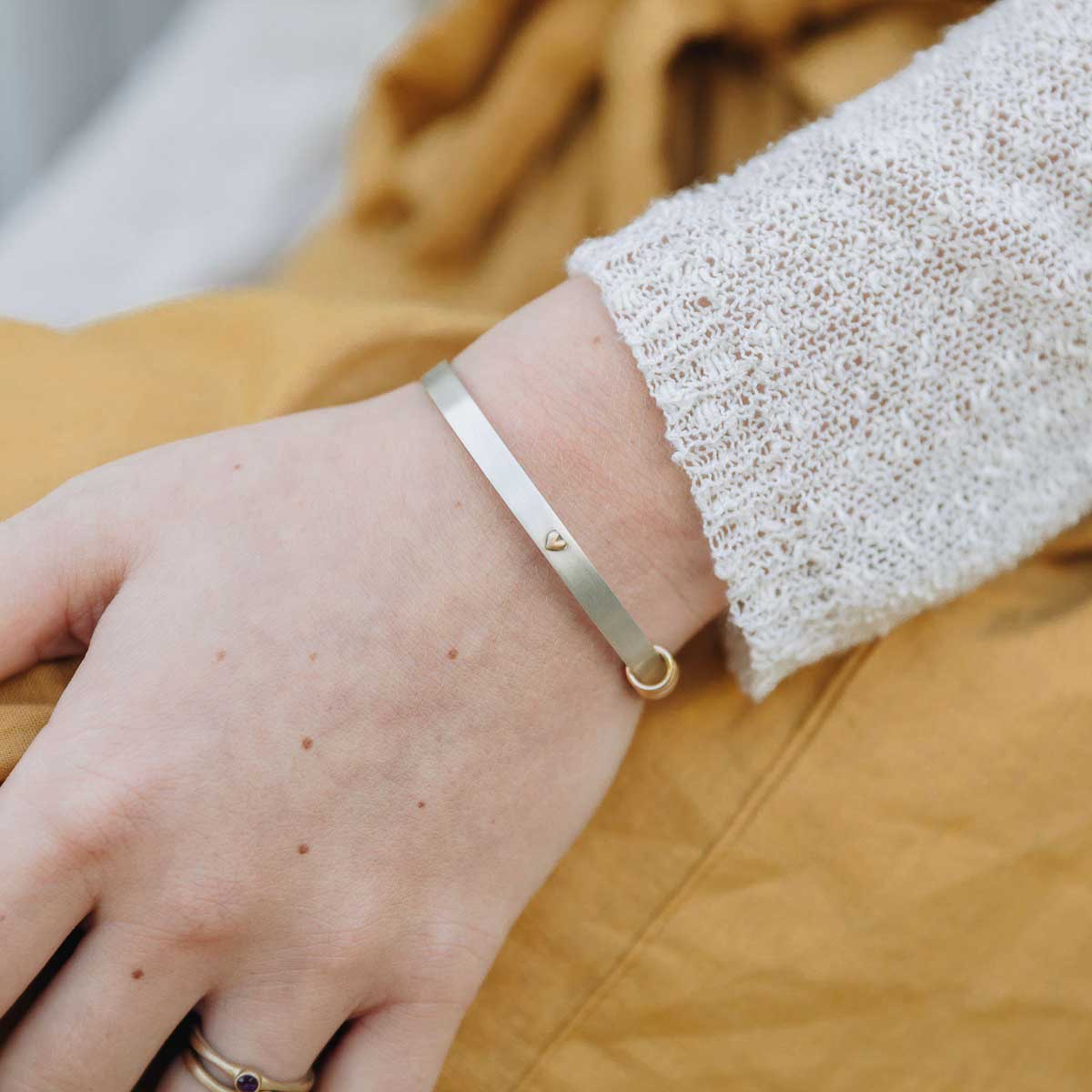 Girl wearing Personalized sterling silver and 10k gold You have my heart cuff with added gold-filled ring charms