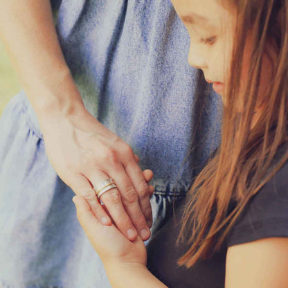 mom wearing the you have my heart spinner ring {sterling silver & 10k gold} holding daughter