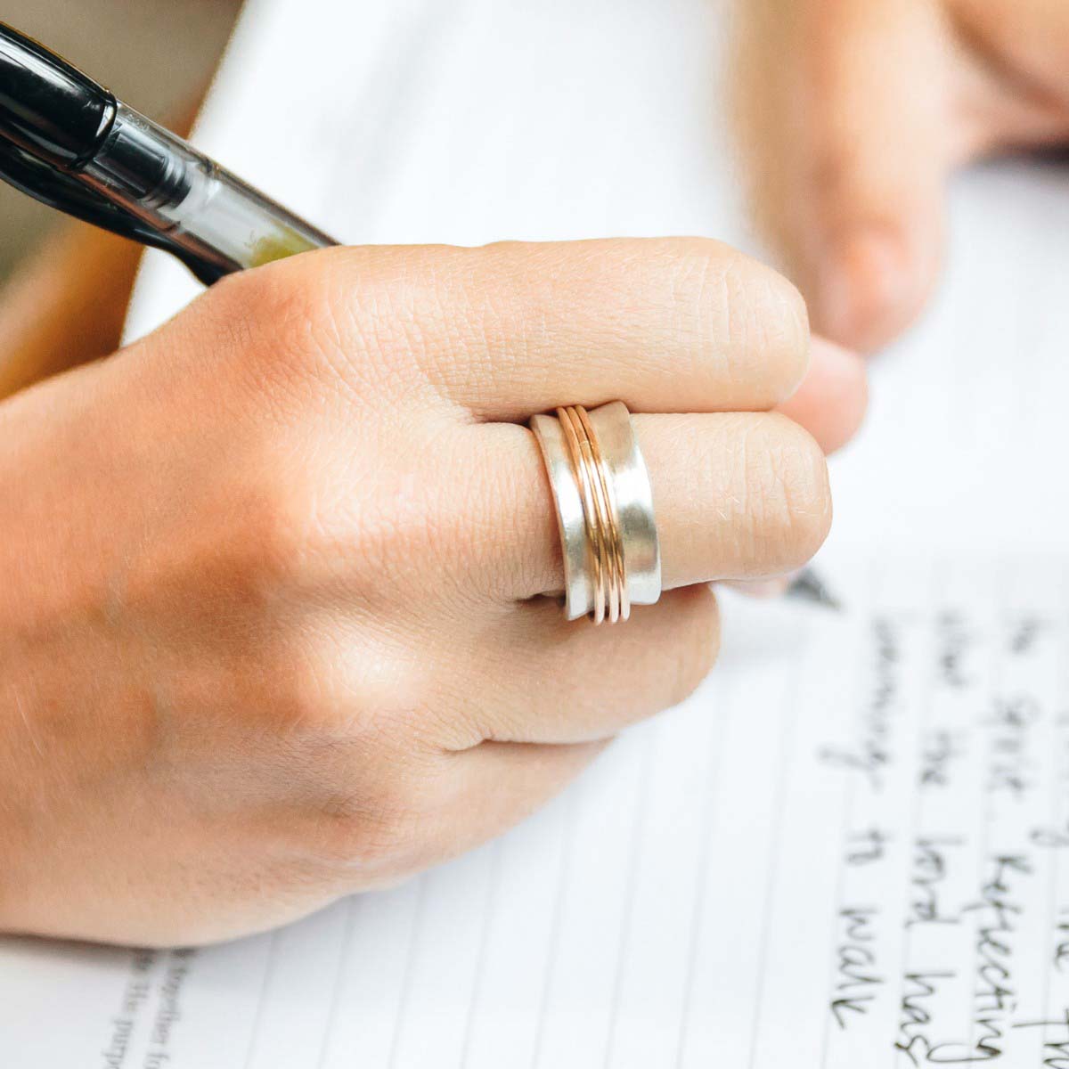 Woman wearing her You Have my Heart Spinner ring with a sterling silver band and gold-filled spinners and phrase engraved on the inside