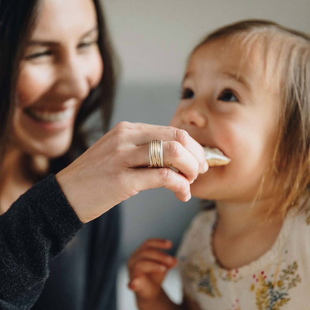 Woman wearing her You Have my Heart Spinner ring with a sterling silver band and gold-filled spinners and phrase engraved on the inside with her daughter