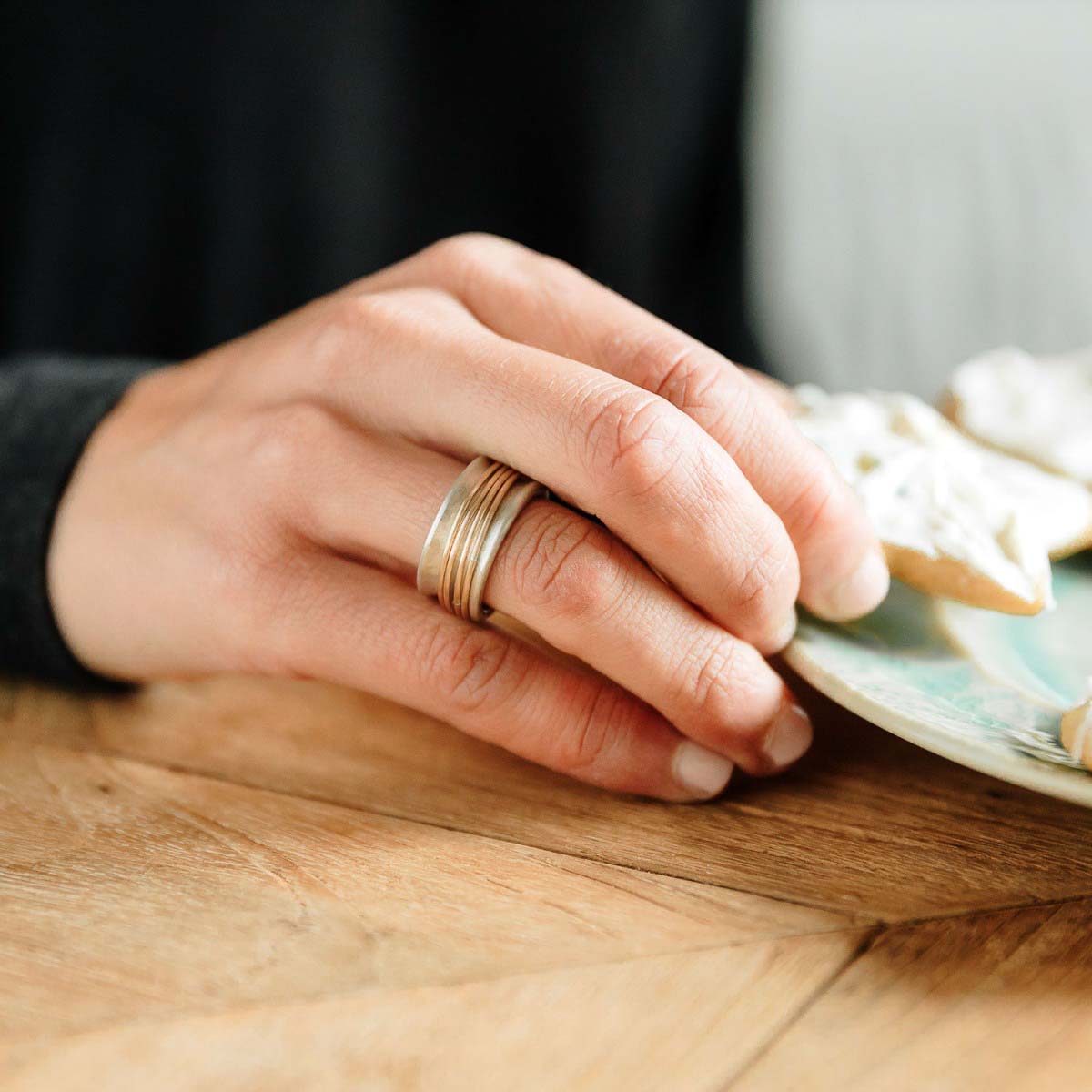 Woman wearing her You Have my Heart Spinner ring with a sterling silver band and gold-filled spinners and phrase engraved on the inside