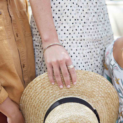 Woman wearing her You Have my Heart Spinner ring with a sterling silver band and gold-filled spinners and phrase engraved on the inside